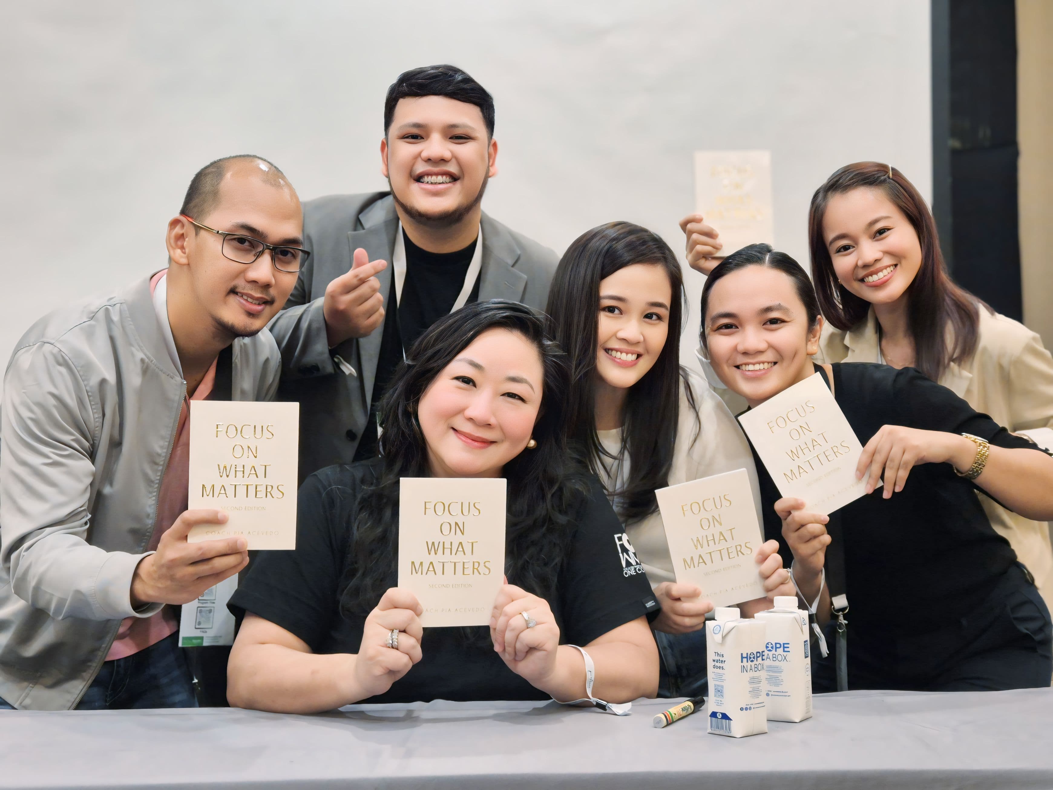 Team holding 'Focus on What Matters' leadership books during certification ceremony