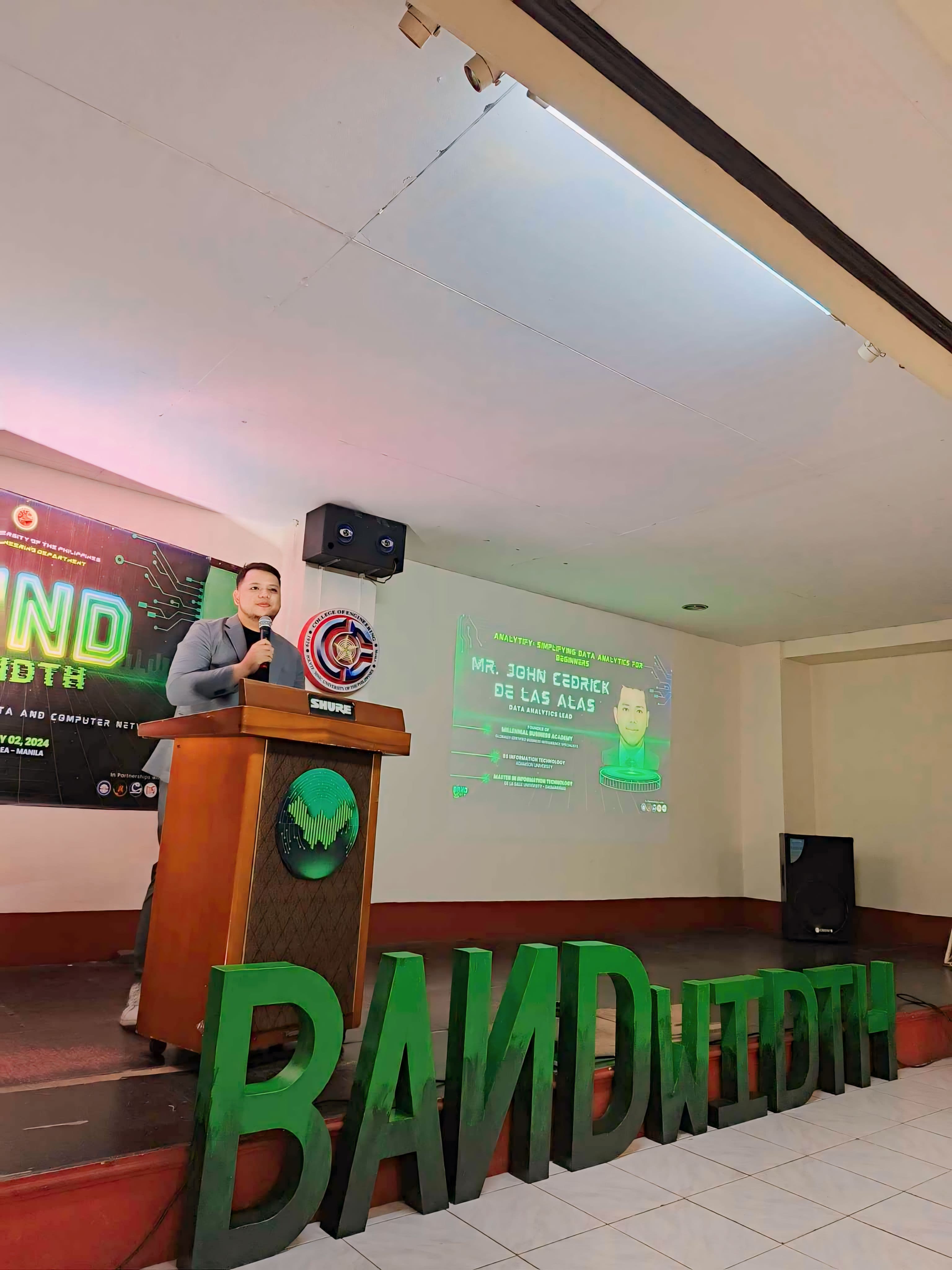 JC presenting at the Bandwidth Seminar podium at PUP Manila with his profile slide visible