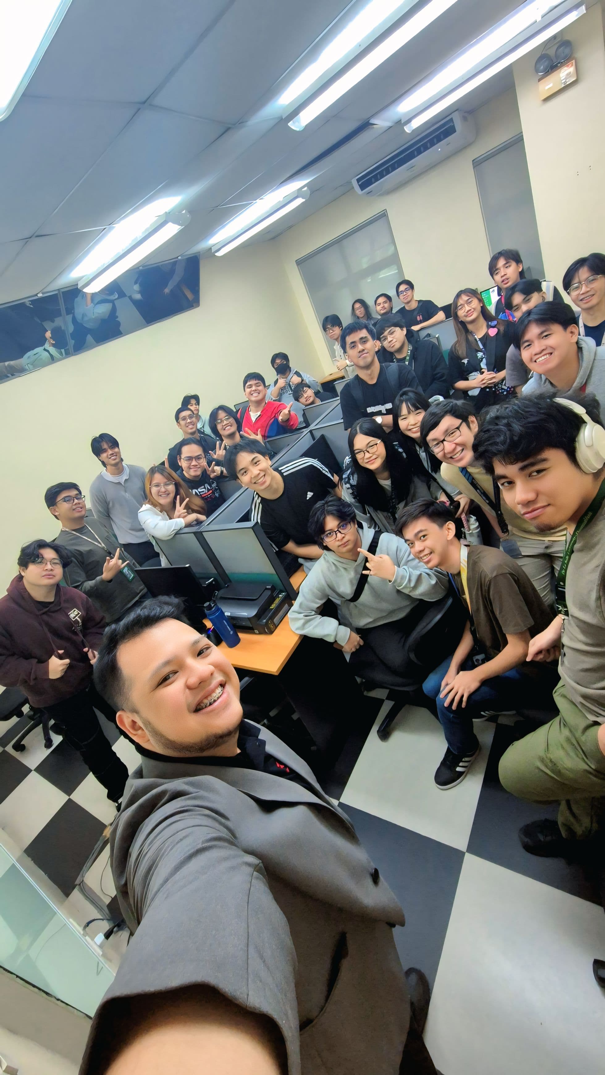 Classroom selfie with JC and DLSU students in tiered lecture hall during IT course