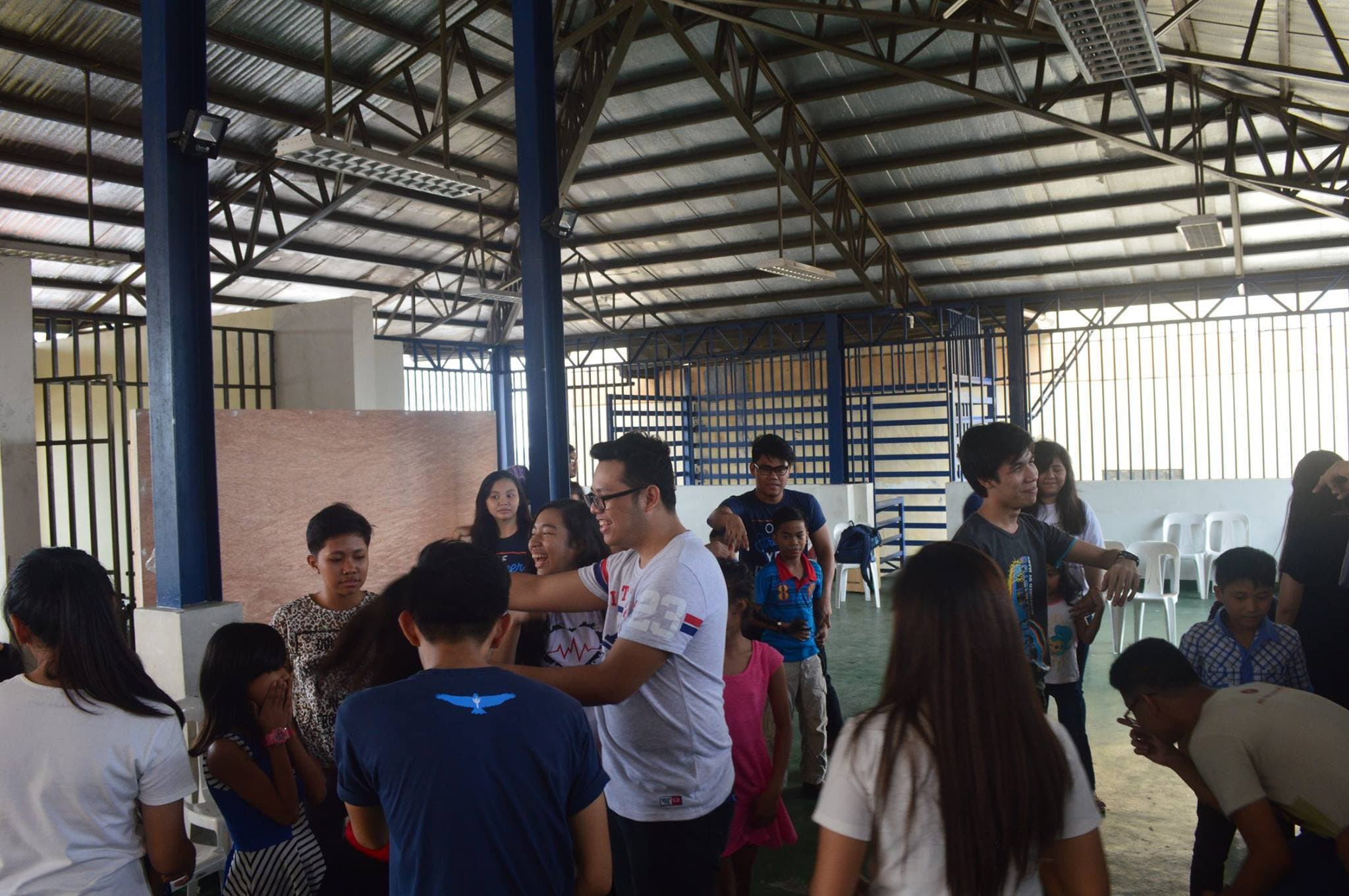 JC with Youth for Christ volunteers in a multi-purpose hall facilitating community activity